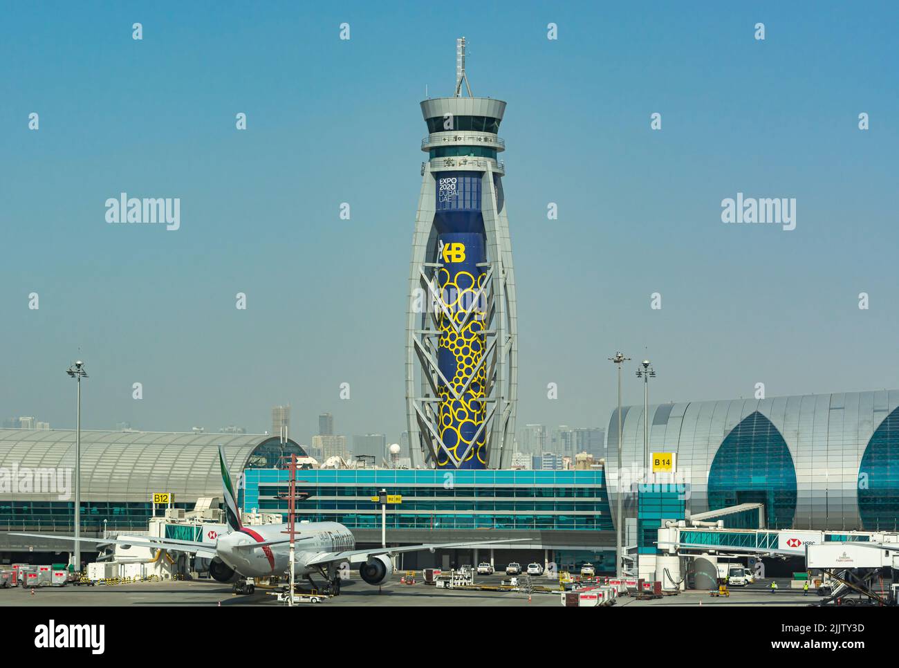 Eine wunderschöne Aufnahme des internationalen Flughafens von Dubai und ein Flugzeug bellten an einem sonnigen Tag im Innenhof gegen den blau bewölkten Himmel in Dubai, VAE Stockfoto