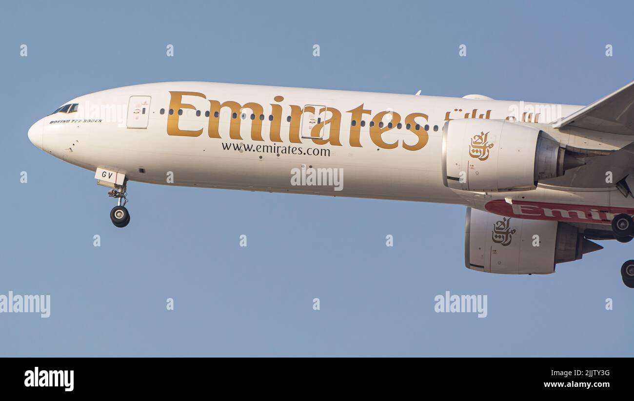 Eine Boeing 777 300 er von der Emirate Airline, die am blauen Himmel vom Dubai International Airport fliegt Stockfoto