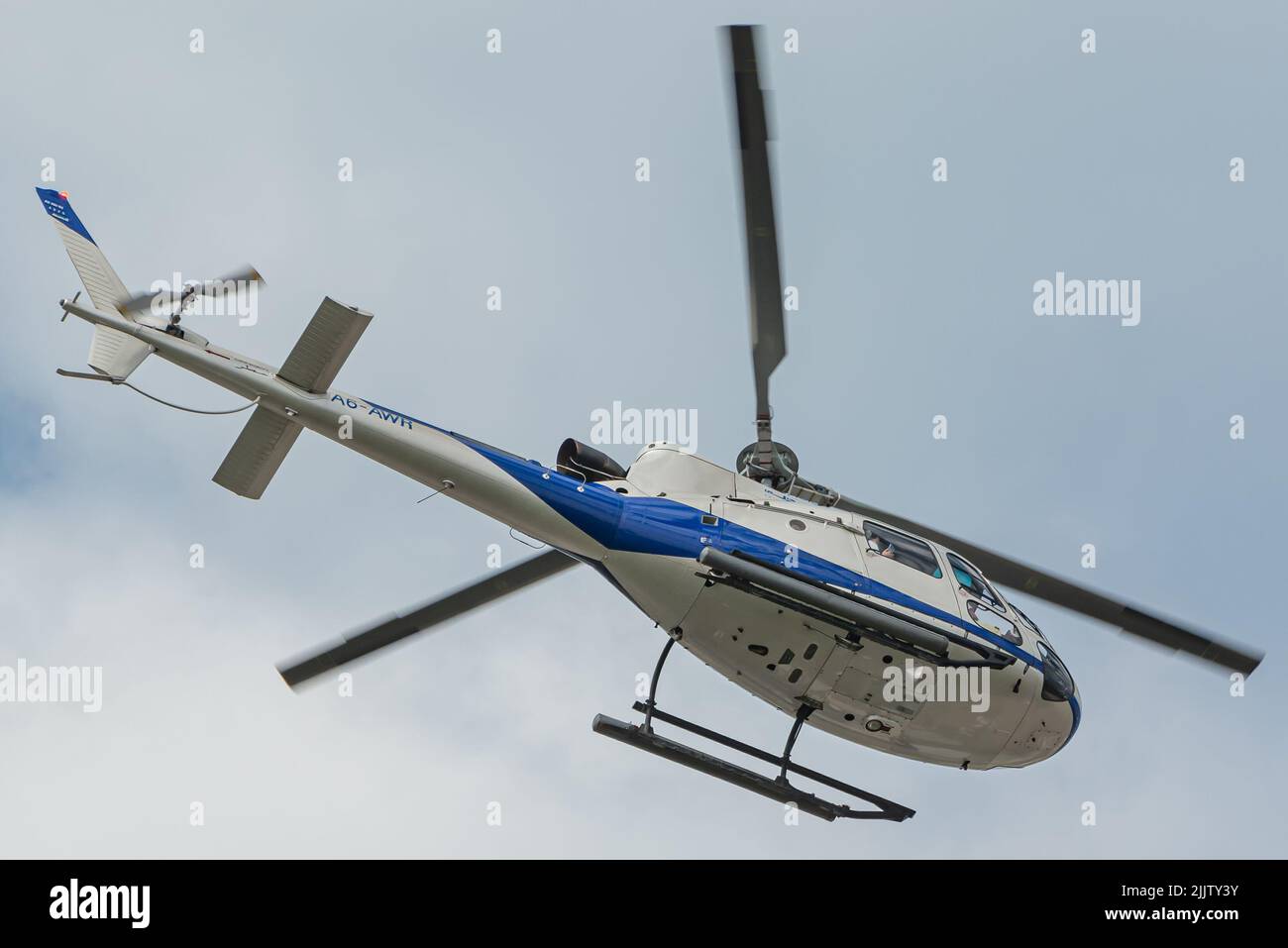 Eine Low-Angle-Aufnahme eines Helicopters Heli Dubai Tours Aerospatiale AS AS350 Ecureuil am blauen Himmel Stockfoto