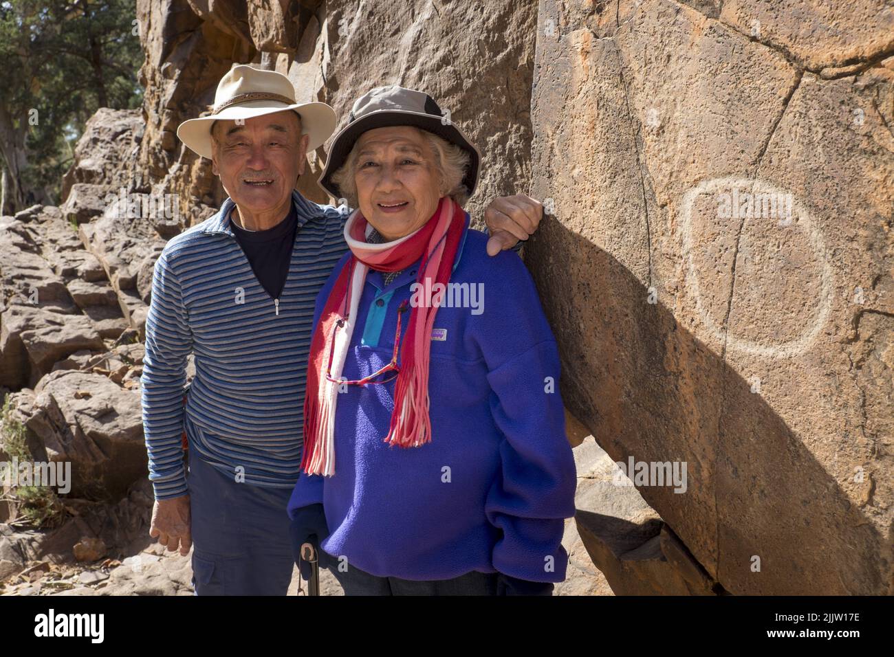 Maurice Lee (86) und seine Frau Wilma Lee (83), gebürtiger Australier, aus China, tourten durch den Sacred Canyon in den Flinders Ranges in Südaustralien. Sowohl Maurice als auch Wilma aktive Senioren gaben erst vor ein paar Jahren das Skifahren auf. Jetzt reisen sie, um ihre Liste der Orte zu füllen, die sie schon immer in Australien besuchen wollten. Sie sind dabei, ihren Hochzeitstag 62. zu feiern. Das Foto zeigt Maurice und Wilma, mit einer der Aborigines-Perraglyphen im Sacred Canyon, die in der Nähe von Wilpena Pound liegt. Stockfoto