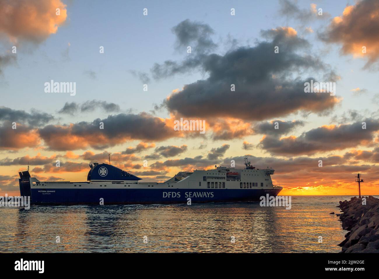 Ein farbenfroher Sonnenuntergang vor den Toren des Hafens von Klaipeda. Litauen während DFDS Seaways Fracht-Passagierfähre, die den Hafen verlässt Stockfoto