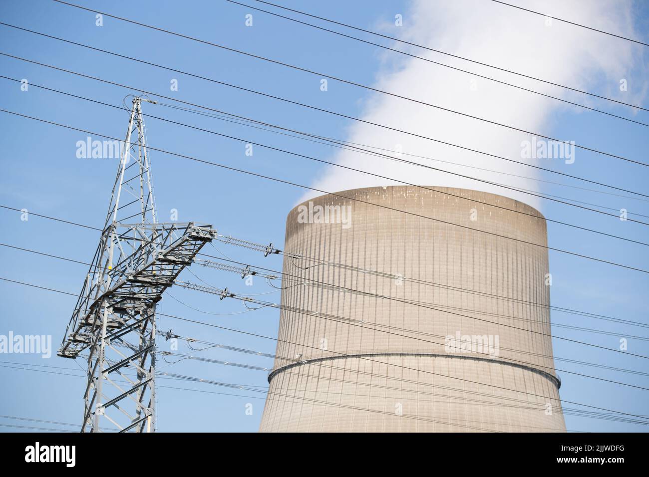 Lingen, Deutschland. 20.. Juli 2022. Blick auf das Kernkraftwerk Emsland (KKE) mit seinem Kühlturm. Im Vordergrund der Mast einer Hochspannungsleitung. Quelle: Friso Gentsch/dpa/Alamy Live News Stockfoto