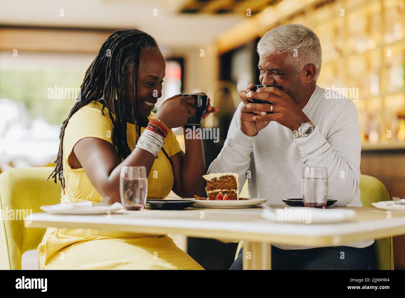 Fröhliches Seniorenpaar, das beim Kaffee in einem Café zusammen lacht. Sorgenfreies Seniorenpaar, das eine gute Zeit in einem Restaurant hat. Glückliches reifes Paar Stockfoto