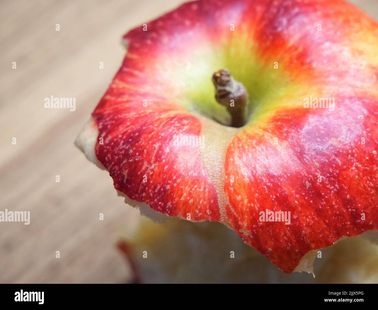 Roter Apfelkern auf einem Holzhintergrund. Ein gebissene Apfel aus der Nähe. Stockfoto