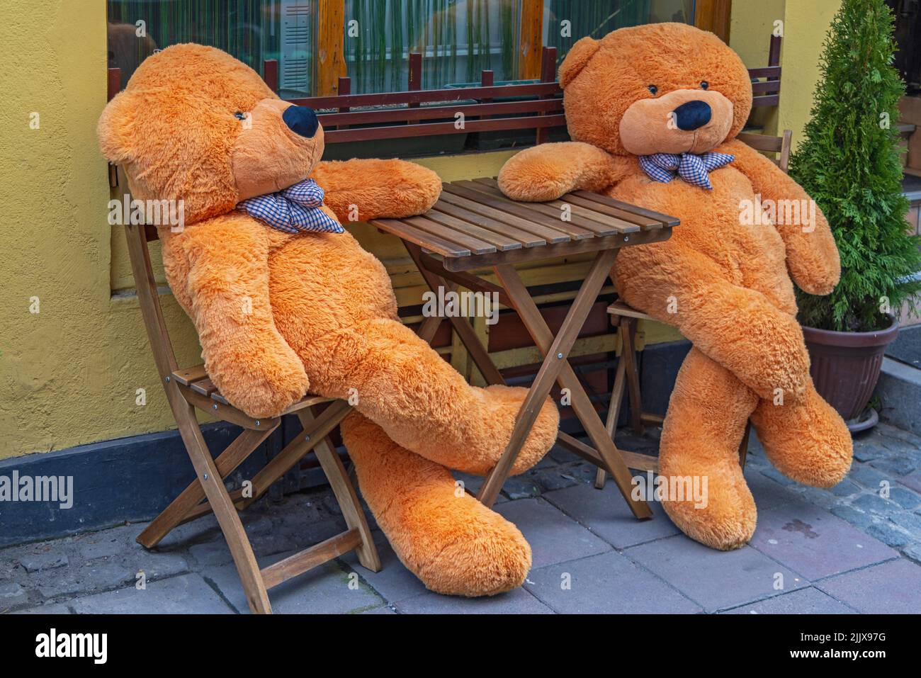 Zwei Teddybären sitzen am Tisch vor dem Restaurant Stockfoto