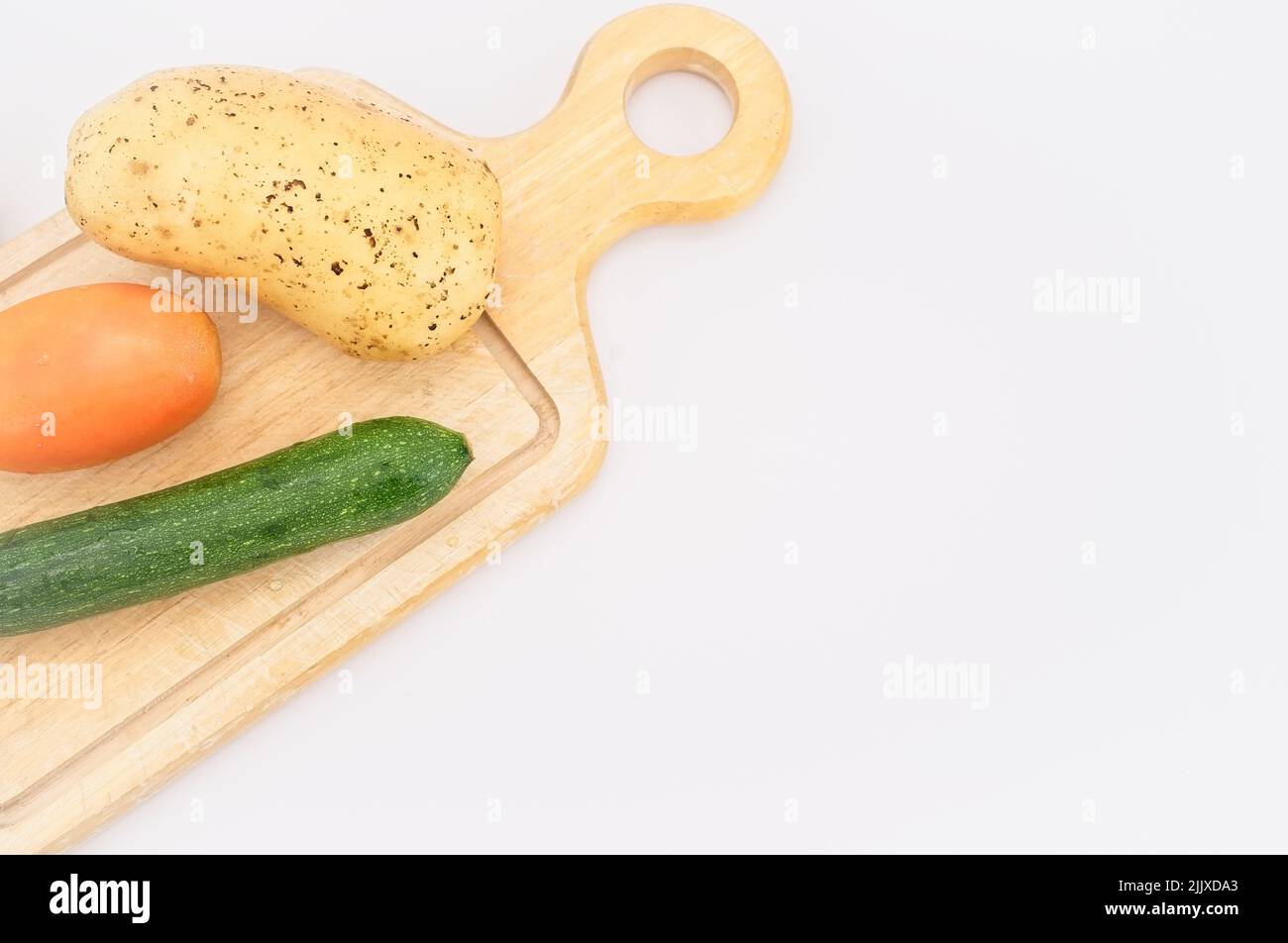 Frisches Gemüse aus biologischem Anbau auf einem hölzernen Schneidebrett mit weißem Küchentuch Stockfoto