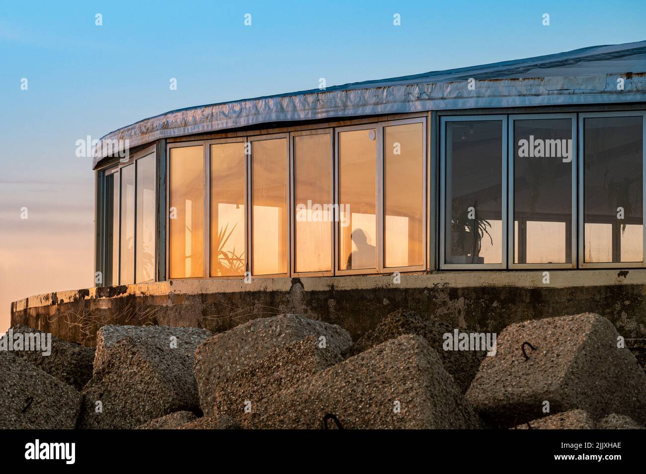 Restaurant mit Erkerfenstern am Meer in der Morgendämmerung Stockfoto