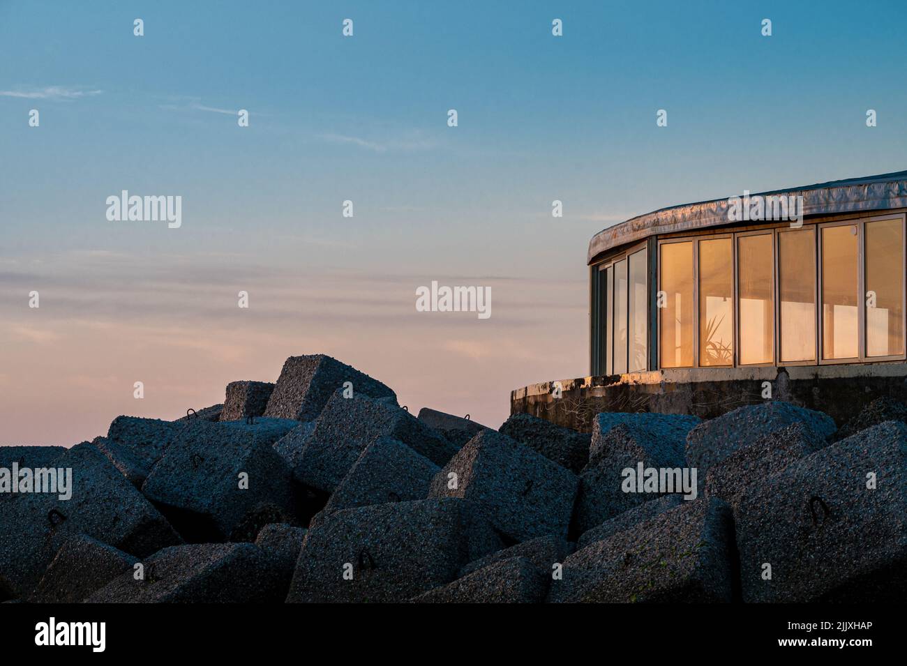 Restaurant mit Erkerfenstern am Meer in der Morgendämmerung Stockfoto