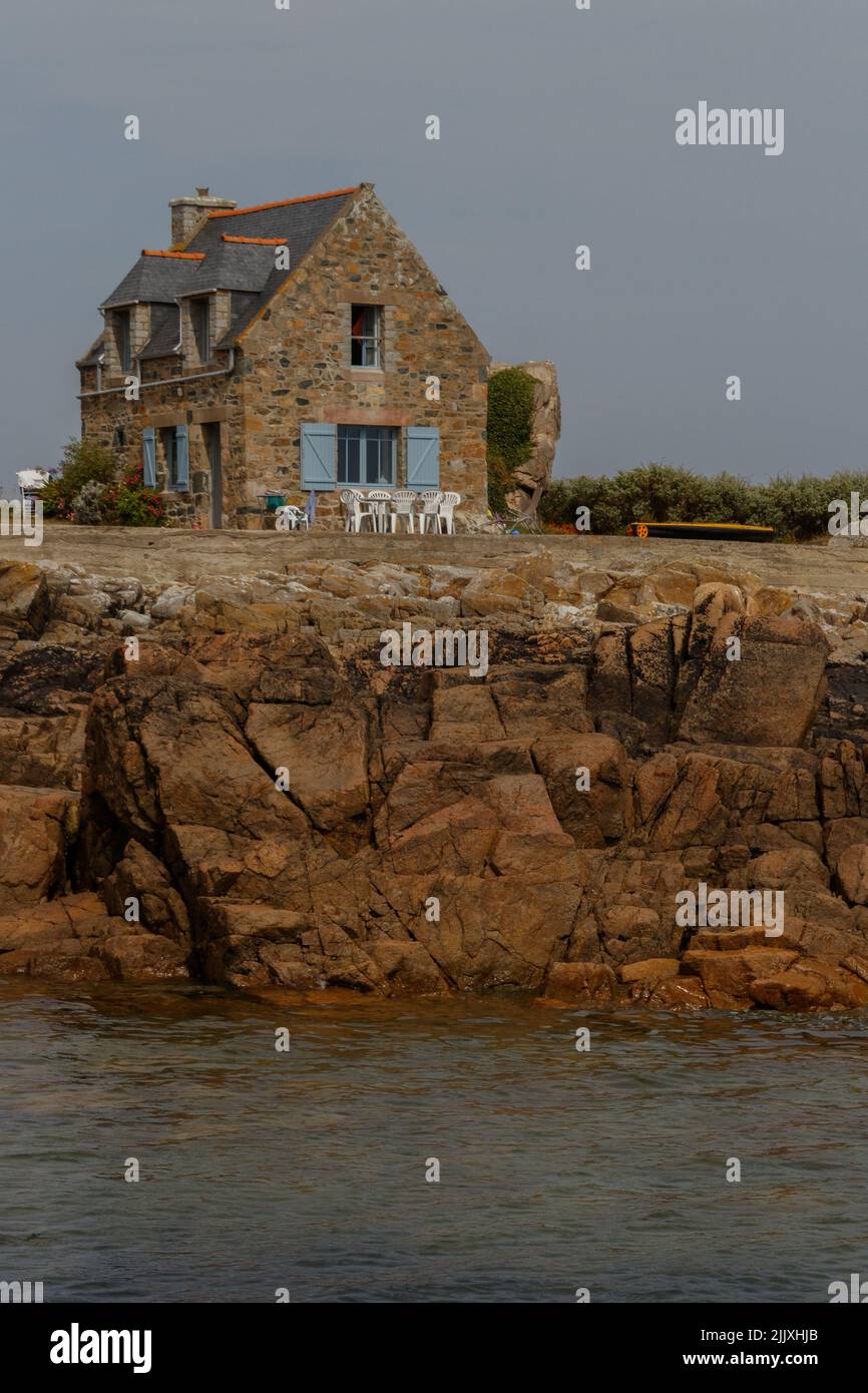 Vertikale Aufnahme des traditionellen bretonischen Steinhauses an der felsigen Atlantikküste des Ärmelkanals von Plougrescant, Bretagne, Frankreich Stockfoto