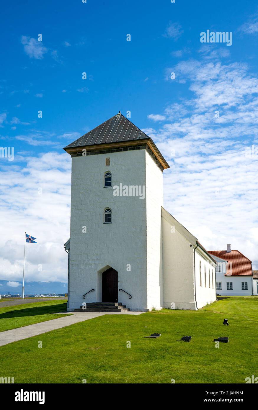 Álftanes, Island - 1. Juli 2022 Vertikale Ansicht der Kirche des Bessastadir, einer bescheidenen Gruppe von weißen, rot gedeckten Gebäuden, die die offizielle r Stockfoto
