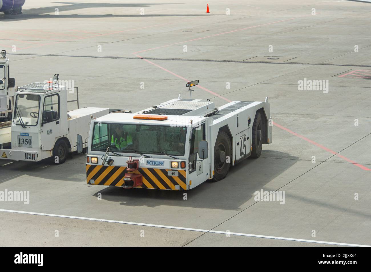 Abschleppwagen, der auf den Parkplatz am Flughafen zurückgeschoben wird Stockfoto