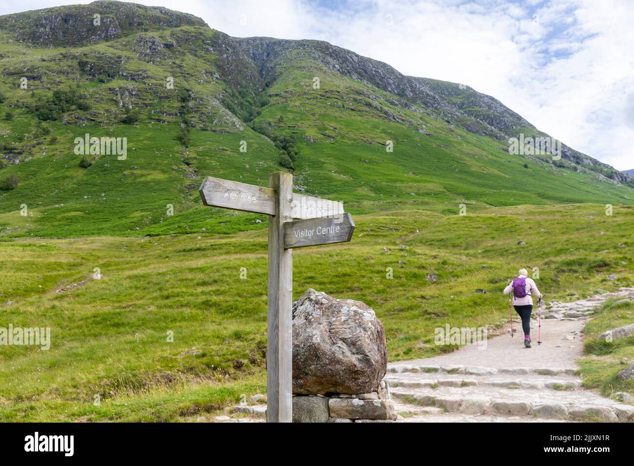 Ben Nevis Mountain Schottland, weibliche Wanderer in ihren fünfziger Jahren beginnt Solo-Wanderung auf den Ben Nevis Berg in Schottland, Sommer 2022, Großbritannien mit Rucksack und Stöcken Stockfoto