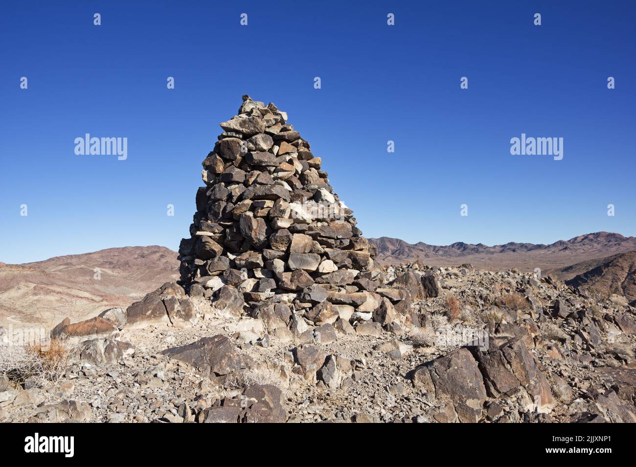 Ein großer Steinhaufen oder eine große Steinhaufen auf dem Gipfel eines Wüstenberges Stockfoto