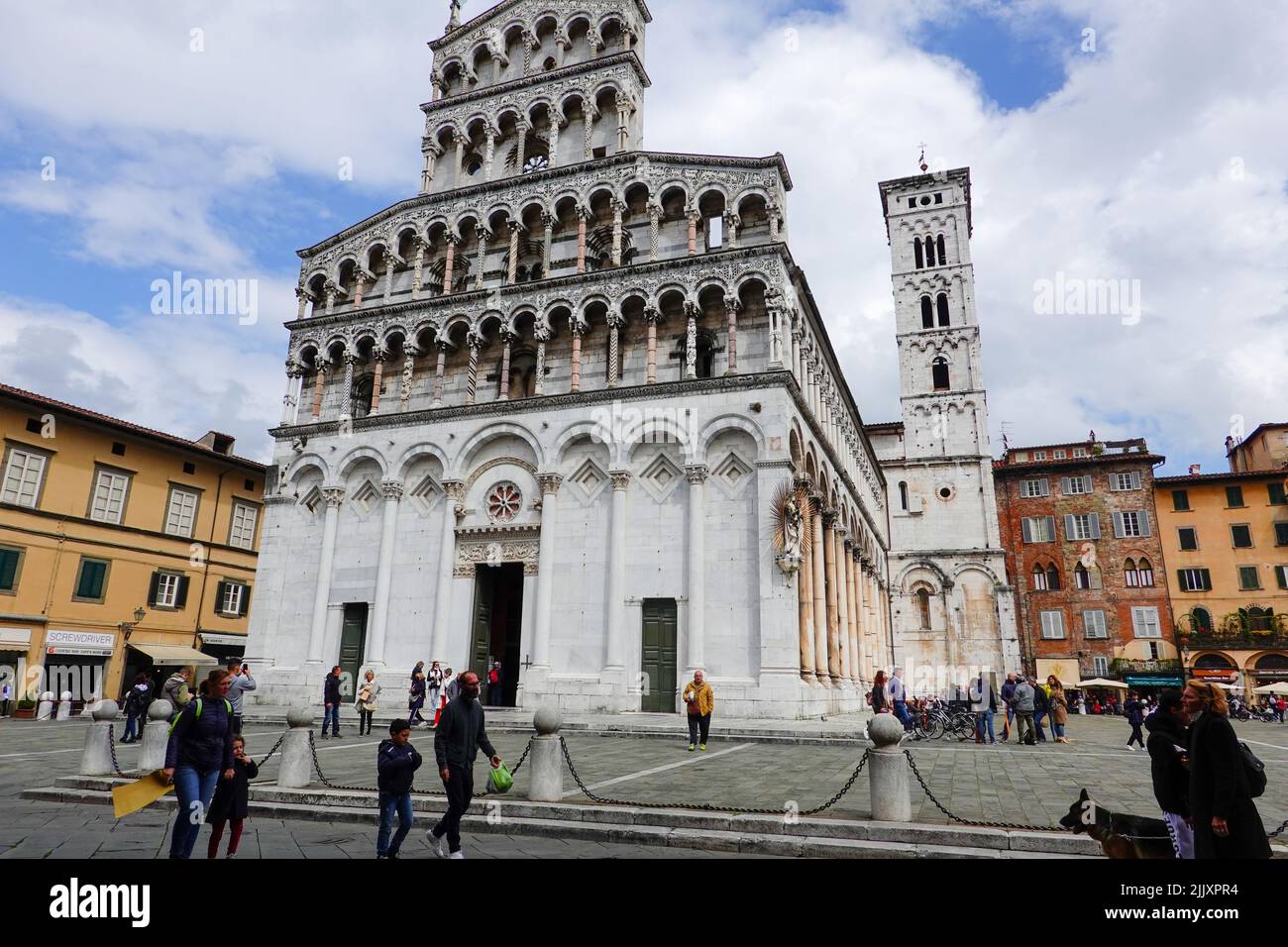 Chiesa di San Michele in Foro, Basilika auf der Piazza di San Michele mit vorbeiziehenden Menschen, Zentrum von Lucca, Toskana, Italien. Stockfoto