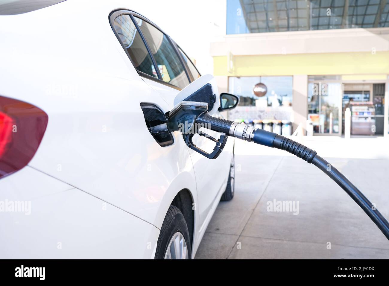 Pumpen von Gas an der Gaspumpe Nahaufnahme des Menschen, der Benzin in das Auto pumpt, an der Tankstelle, steigende Benzinpreise, Copy Space. Stockfoto