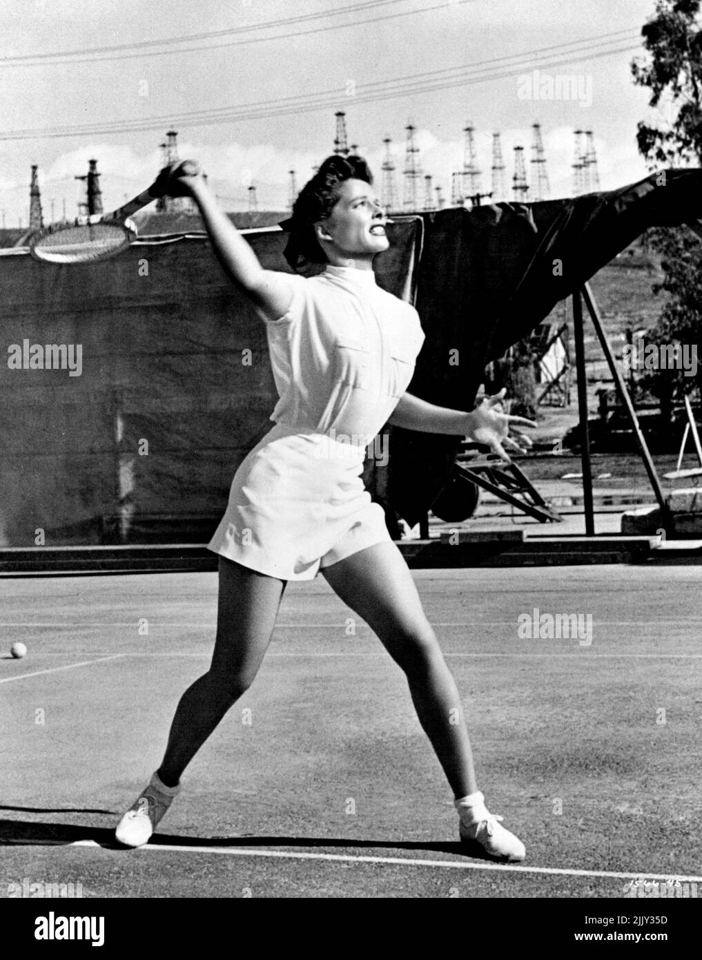 .. Katharine Hepburn ist das Tennis-Ass, das in „Pat and Mike“ von M-G-M, in dem sie mit Spencer Tracy mitspielt, die Liebe zu einem Spiel spielt. Als Allround-Athletin wird sie von Tracy geleitet, einer harten Sportmanagerin, mit der sie romantisch und professionell verstrickt wird. Die Hauptrollen führen auch Aldo Ray, William Ching und Sportstars wie Babe Didrikson Zaharias, Gussie Moran, Frank Parker, Don Budge, Alice Marble, Helen Dettweiler, Beverly Hanson und Betty Hicks. Regie: George Cukor. Produziert von Lawrence Weingarten. Geschrieben von Ruth Gordon und Garson Kanin. 1. September 1952. Stockfoto