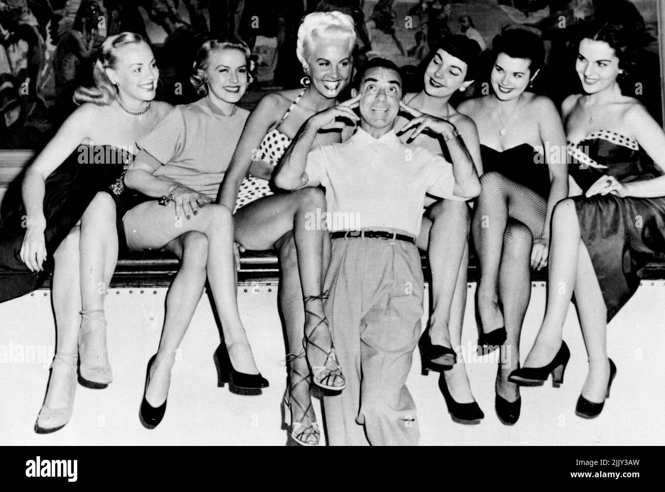 Eddie Cantor wählt Einen Chorus -- (von links nach rechts) Edna Ryan, Ronnie Catley. Siri, Eddie Cantor selbst, Gwen Smith, Nickie Miller und Helaine Grayson. Als Eddie Cantor Mädchen schickte, um mit ihm im Fernsehen zu erscheinen, tauchten so viele wunderschöne Kreaturen auf, dass die Auswahl der sechs Gewinner fast so zufällig wurde, wie den großen Esel festzumachen. Dennoch wählte Eddie seine sechs und Hier seid ihr. 03. Oktober 1951. (Foto von Paul Popper, Paul Popper Ltd.). Stockfoto