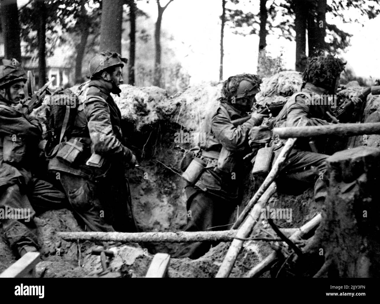 Arnhem British Airbourne Trupps in Action -- Fallschirmjäger, die in einem Granatloch Deckung finden. Fast 2.000 britische Truppen der Airbourne Division wurden nach ihrem hartnäckigen 8-tägigen Kampf, der am 17.. September begann, aus Arnhem evakuiert. Diese Bilder zeigen Szenen während der Landung in Holland und die Aktionen im Arnhem-Gebiet. 04. Dezember 1944. (Foto von British Official Photograph). Stockfoto