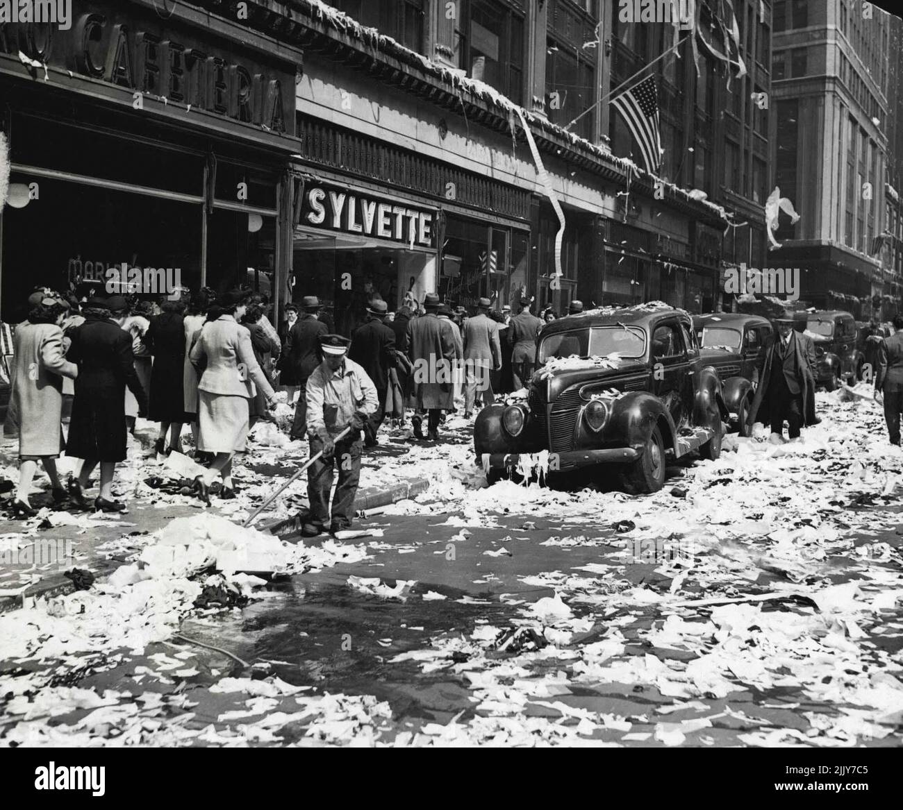 Nachwirkungen -- ****** Die Sixth-Street und die Sixth-Avenue, New York City, stellten dem einjährigen Straßenreiniger ein Problem dar, Papier zu räumen, das von den fröhlichen Machern, die das Ende des Krieges in Europa feierten, herumgeschleudert wurde. 5. Juli 1945. (Foto von Associated Press Photo). Stockfoto