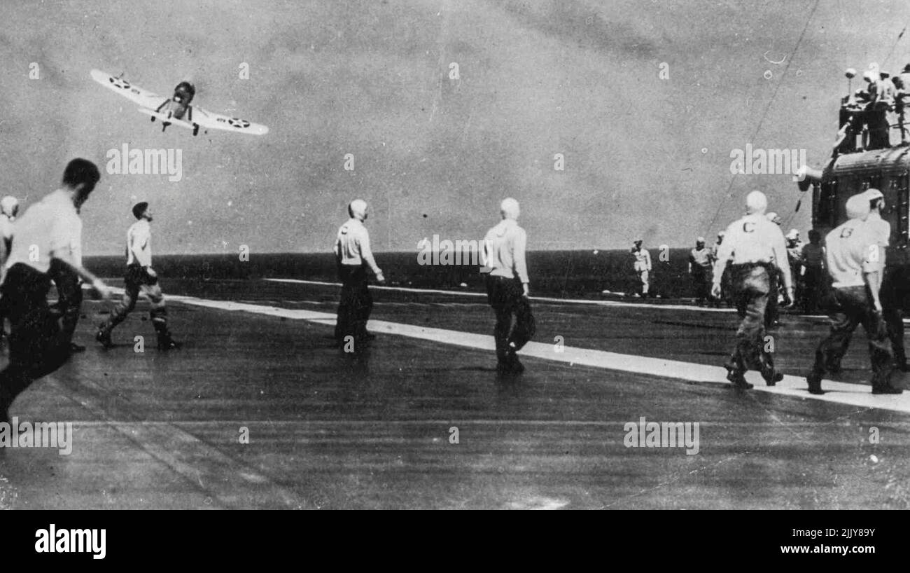 Von „To Battle“ vom Flugdeck des Frachtführers „Lexington“ aus. -- Flugzeuge der U.S.S. Die Fluggesellschaft „Lexington“ stürzt sich auf das Flugdeck. Durch die enge Straßenbahnarbeit von Mitgliedern der Crew an Deck des Fluges (Pullover sind mit Buchstaben beschriftet) können diese Arbeiten reibungslos ablaufen. 12. November 1941. (Foto von Sport & General Press Agency Limited) Stockfoto