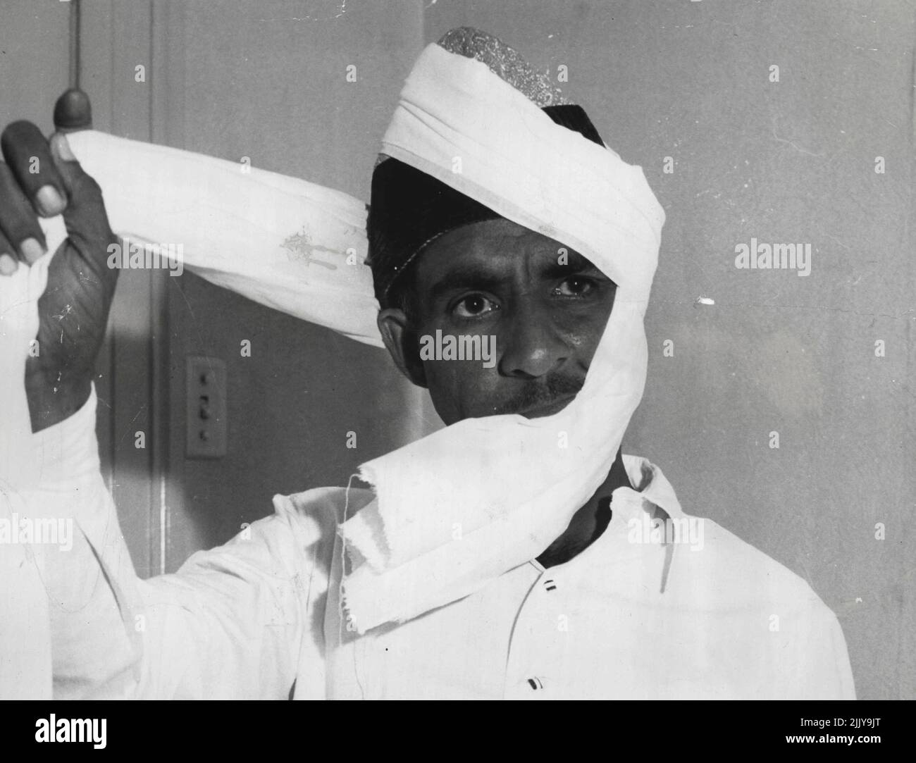 Yakub, der persönliche Diener des pakistanischen Hochkommissars für das Volk (jetzt in Sydney), zeigt den richtigen Weg zu einem „Pfau-Turban“. 18. Juli 1950. Stockfoto
