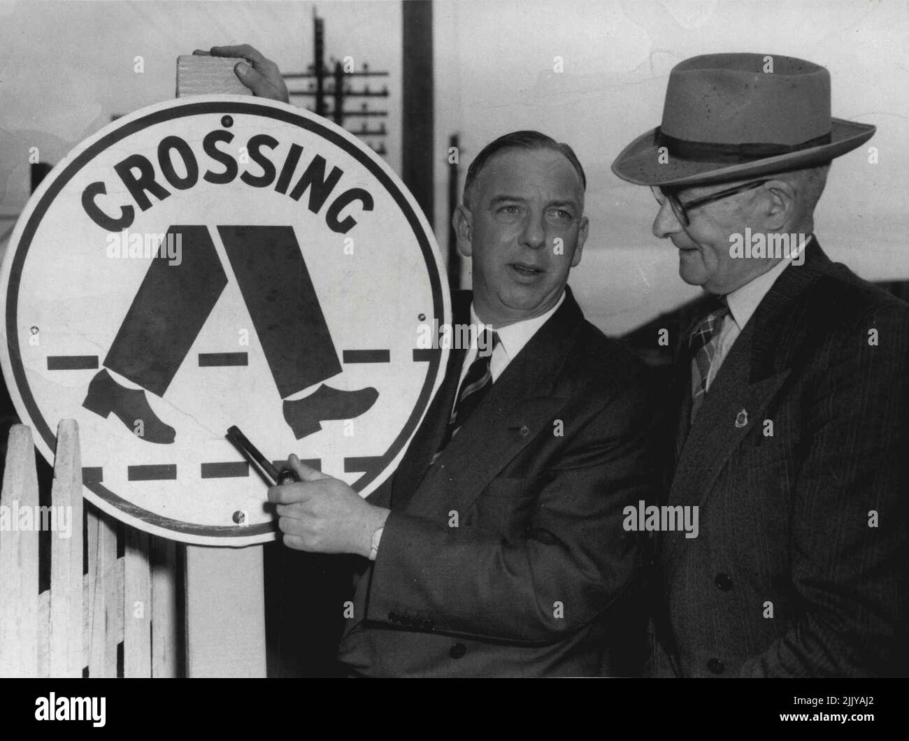 Das neue „Trouser“-Fußgängerübergangsschild in Moorabbin - das erste in Melbourne - wurde heute vom Chefsekretär, Herrn Rylah, inspiziert. Es wurde in der Station Street gegenüber der Moorabbin Station errichtet. Mit Herrn Rylah ist Moorabbin's Stadtingenieur, Herr P. C. Rowan (rechts), der sagte, seine Gemeinde sei „nur Glück genug“, um die neuen Zeichen zuerst zu bekommen. Nach Angaben von Herrn Rylah werden die Schilder sofort aufgestellt, sie werden in ganz Australien zum Standard. 26. September 1955. Stockfoto