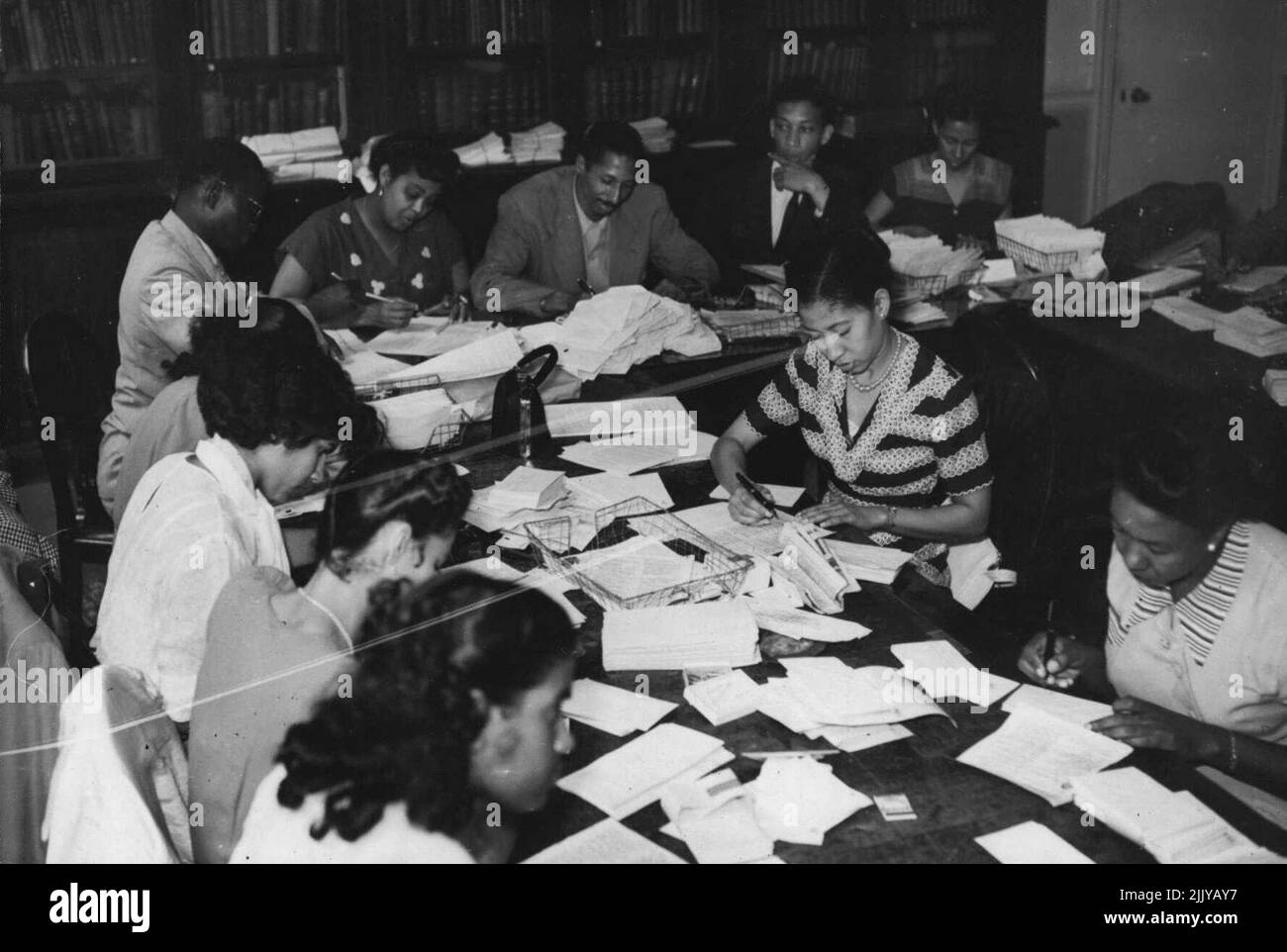 Londons Westinder helfen bei der Arbeit zur Unterstützung von Notlagen - Studenten und andere Mitglieder der jamaikanischen Kolonie helfen beim Senden von Appellen am Hauptsitz des Westindien-Komitees in London. Hinten in der Mitte ist Herb McKenley, der berühmte Athlet. Mitglieder der jamaikanischen Kolonie in London helfen nun in jeder erdenklichen Weise dabei, die Hilfe für das jamaikanische Volk, das unter den Auswirkungen des jüngsten Hurrikans leidet, zu beschleunigen. 14. September 1951. (Foto von Sport & General Press Agency Ltd.). Stockfoto