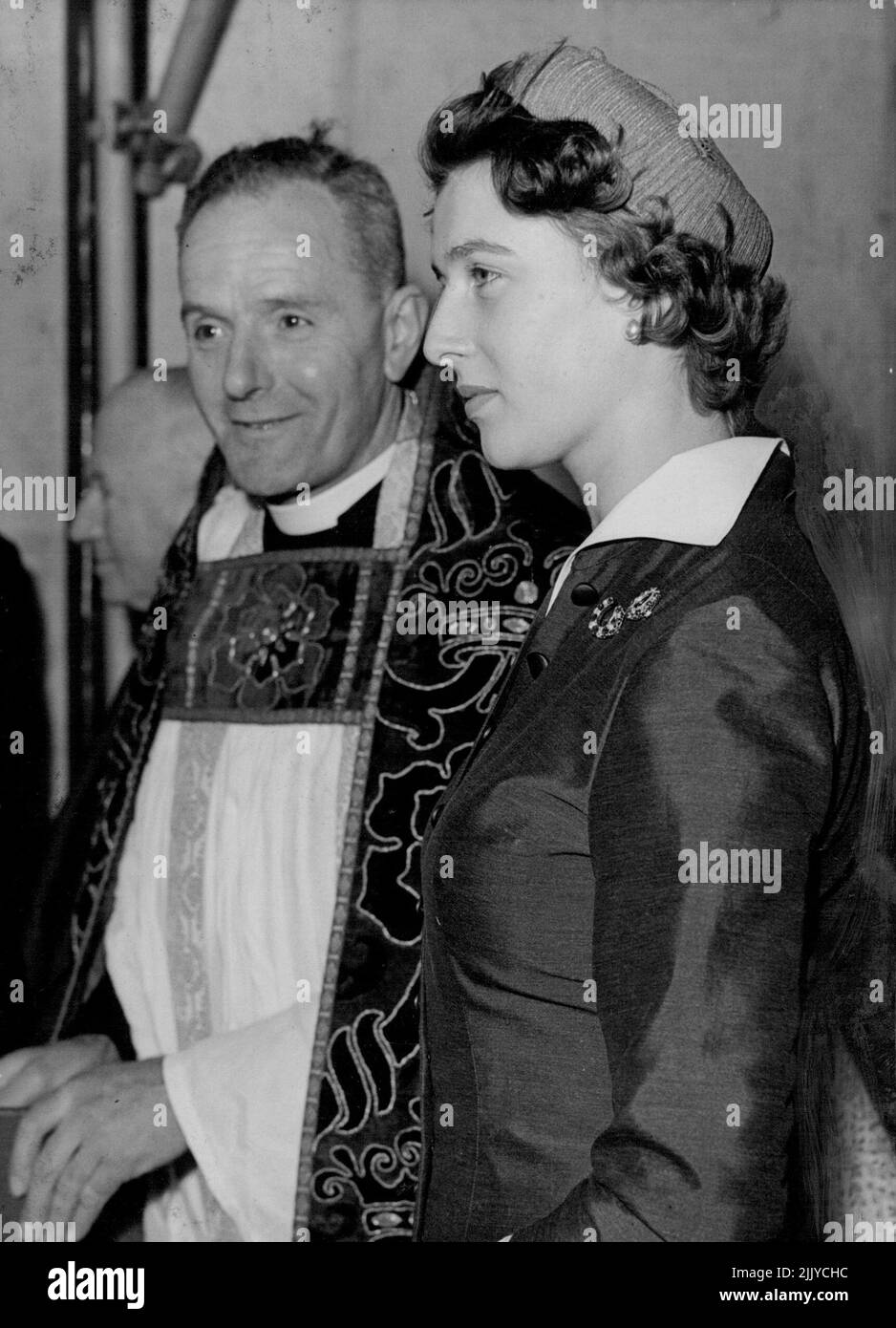 Ihr erster Foundation Stone - Prinzessin Alexandra, die zwei diamantene Pferdeschuhe auf ihrem grauen Kleid trägt, mit dem Rev. R. McIntyre. Prinzessin Alexandra von Kent, 17-jährige Cousine von Königin Elizabeth, legte gestern ihren ersten Grundstein, auf dem neuen. St. Paul's Church of England Schule, Walworth, London. Die neue Schule von $70.000 wird 450 Schüler beherbergen, im Vergleich zu 300 Schülern der heutigen Schule. 07.Mai 1955. (Foto von Paul Popper, Paul Popper Ltd.). Stockfoto