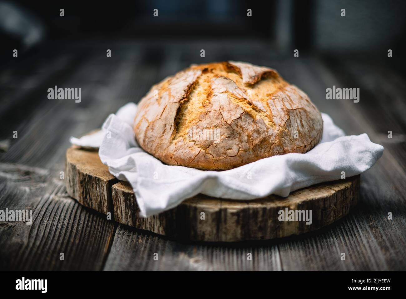 Traditionelles Sauerteig-Brot mit roughiger Schale auf einem rustikalen Holztisch. Fotos von gesunden Lebensmitteln Stockfoto