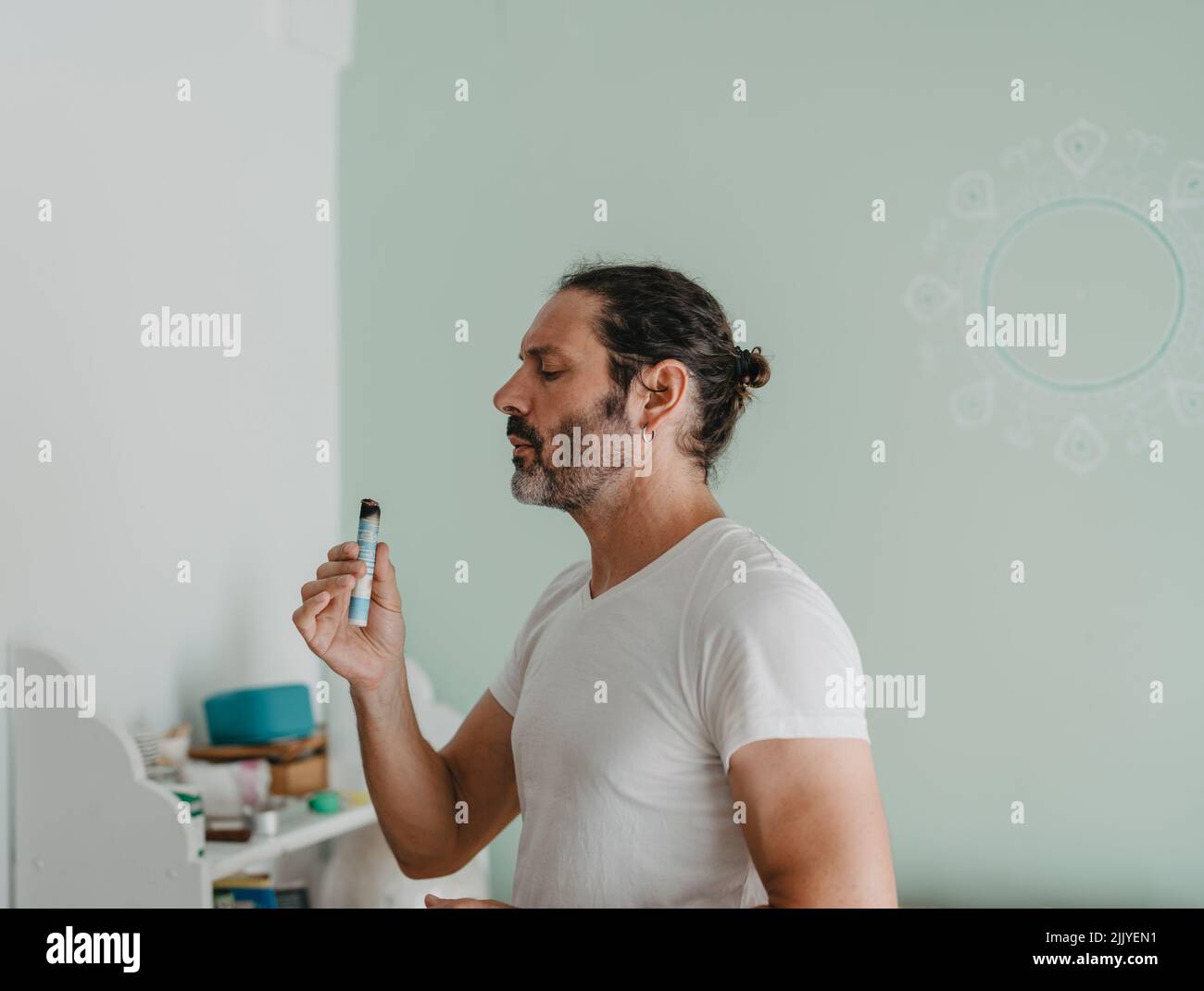 Akupunkturist bläst eine Moxa-Zigarre, um sie zu entzünden Stockfoto