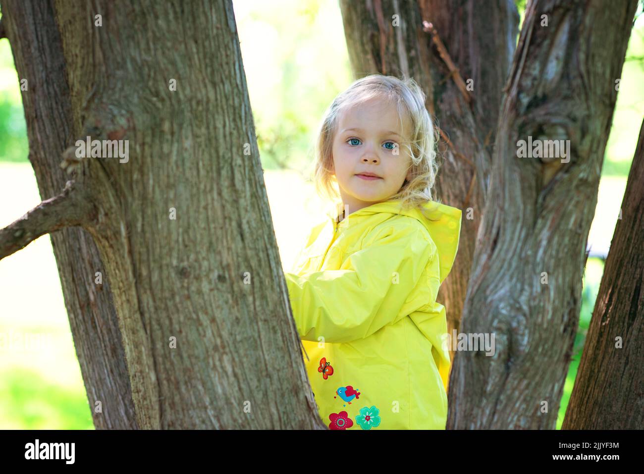 Blonde Kleinkind Mädchen in gelben Regenmantel. Stockfoto