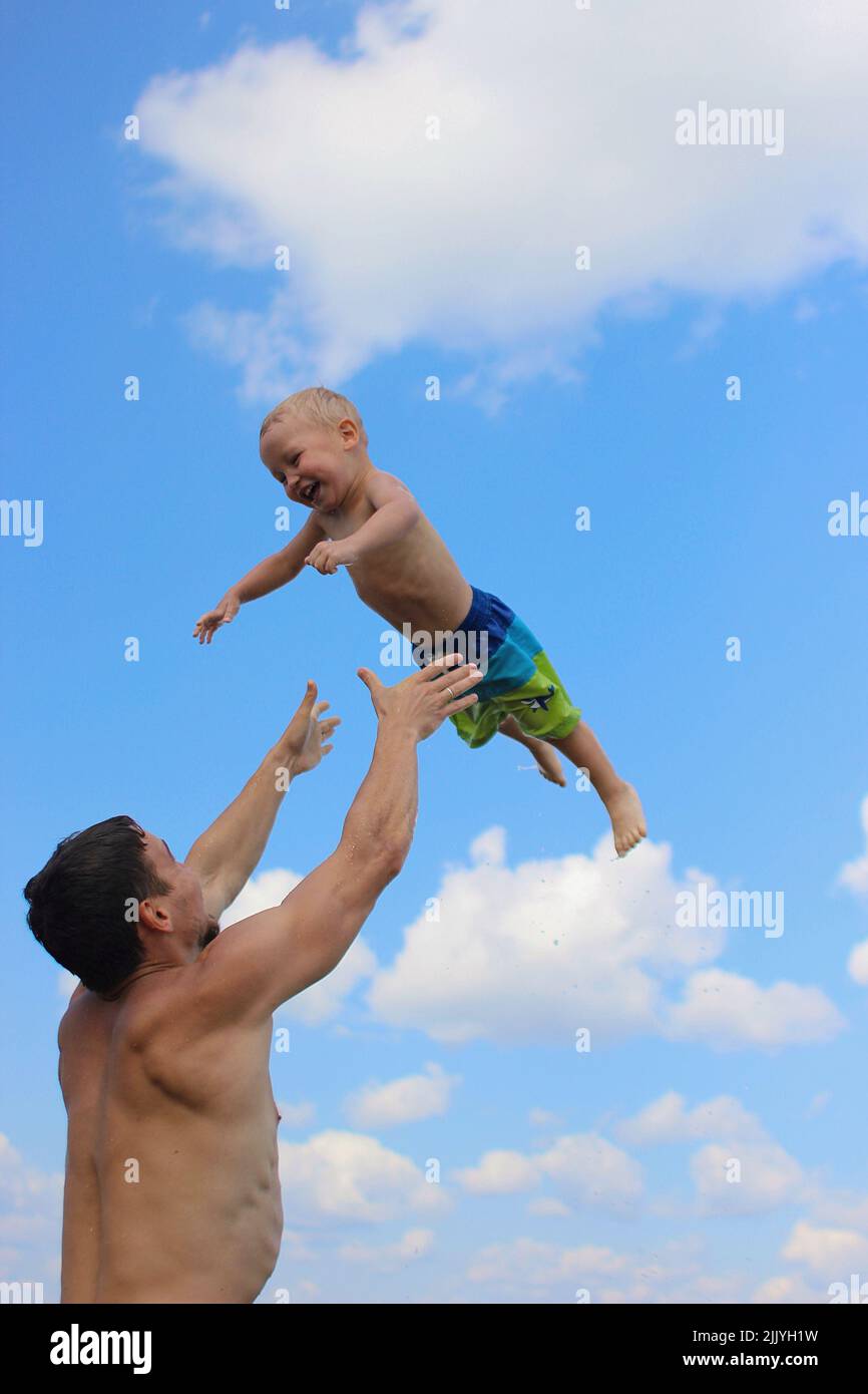 Vater wirft Sohn in den Himmel Stockfoto