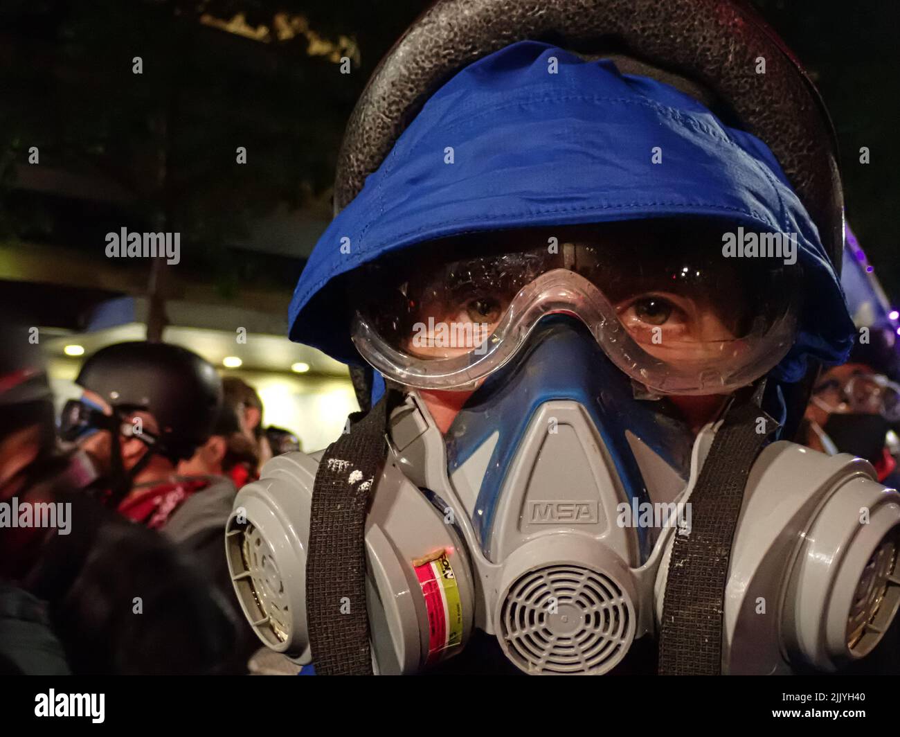 Ein Protestler steht bereit, damit die Polizei Tränengas auf einen Protest in Portland, Oregon, werfen kann Stockfoto