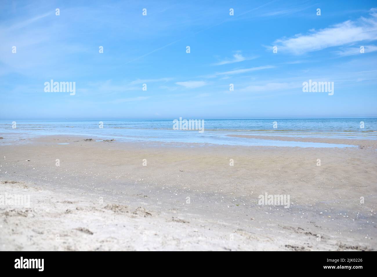 Schöner, natürlicher und landschaftlicher Blick auf den Strand und den blauen Himmel über dem Horizont mit Kopierfläche. Eine friedliche und ruhige Szene von endlosem Sandwasser Stockfoto