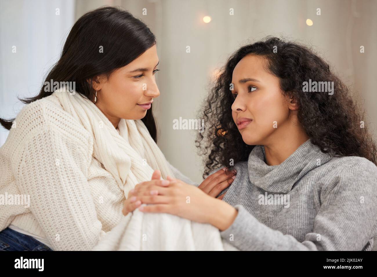 Ich bin hier für Sie, Freund. Zwei Freunde, die traurig aussehen, während sie zu Hause reden. Stockfoto