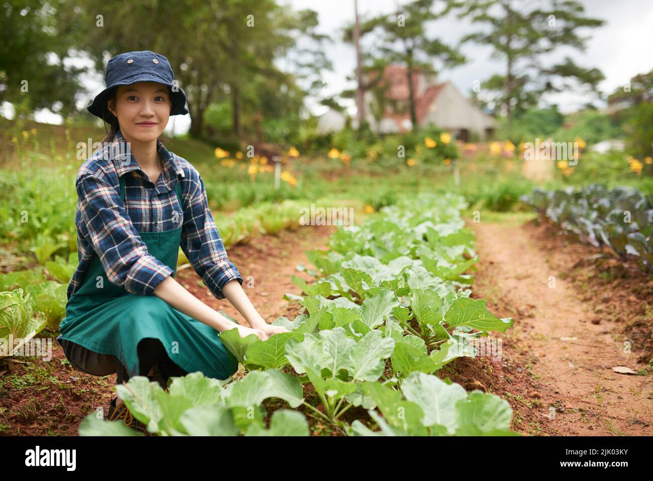 Porträt einer fröhlichen jungen asiatischen Frau, die im Garten arbeitet Stockfoto