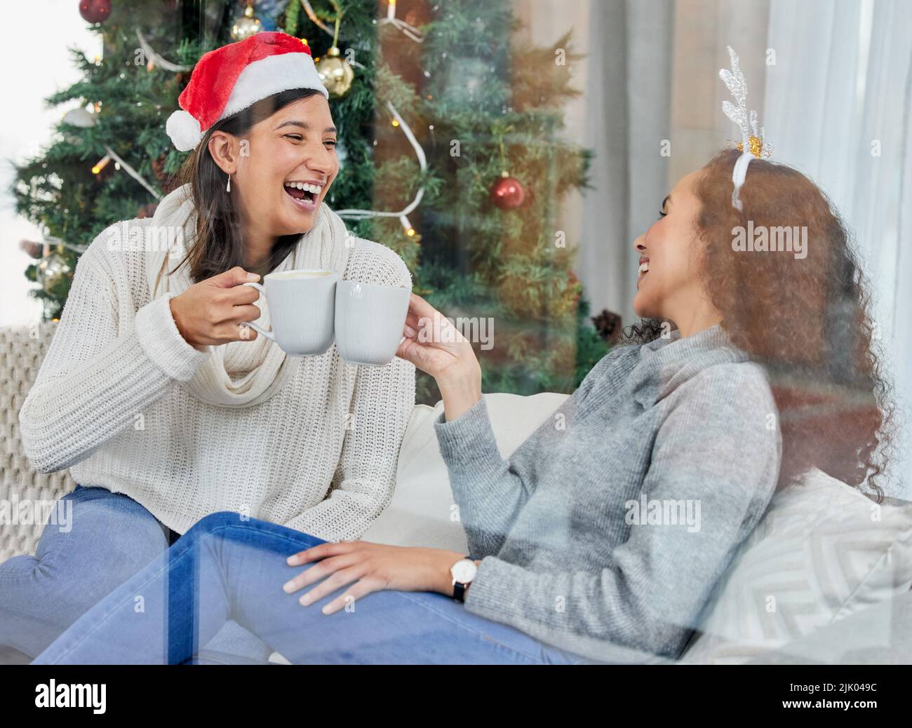Cheers to US. Zwei junge Frauen trinken Kaffee zu Hause. Stockfoto