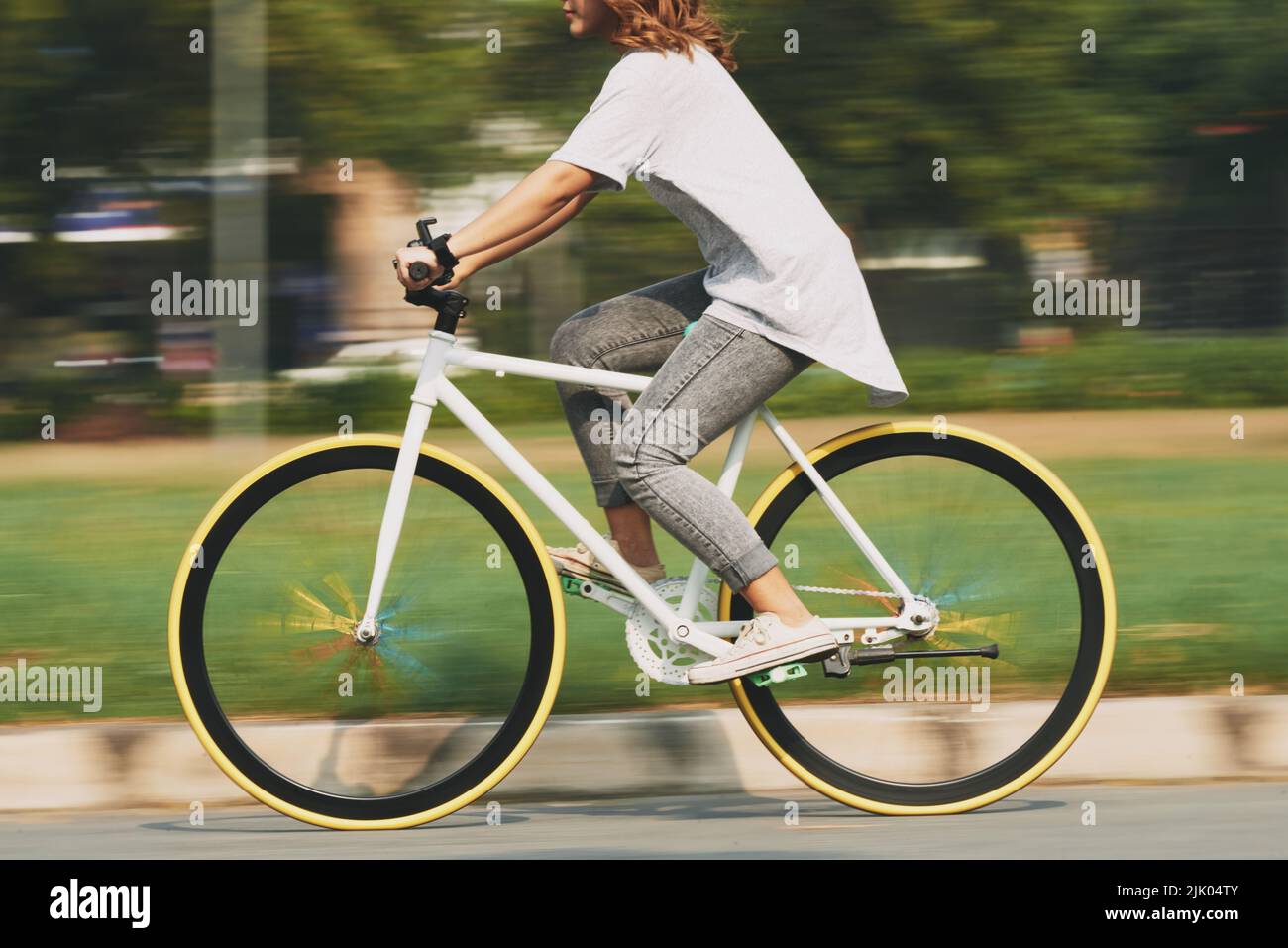 Zugeschnittenes Bild einer jungen Radfahrerin, verschwommene Bewegung Stockfoto