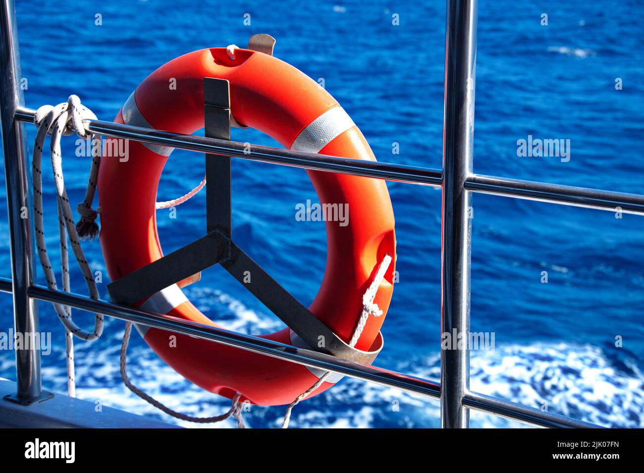 Rettungsweste auf dem Zaun des Schiffes gegen blaues Meer Stockfoto