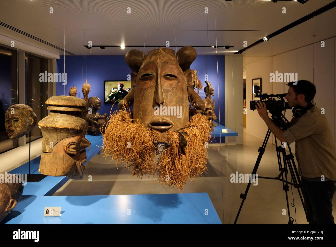 Ein Videofilmer, der afrikanische Artefakte in einer Galerie in Tel Aviv, Israel, fotografiert Stockfoto