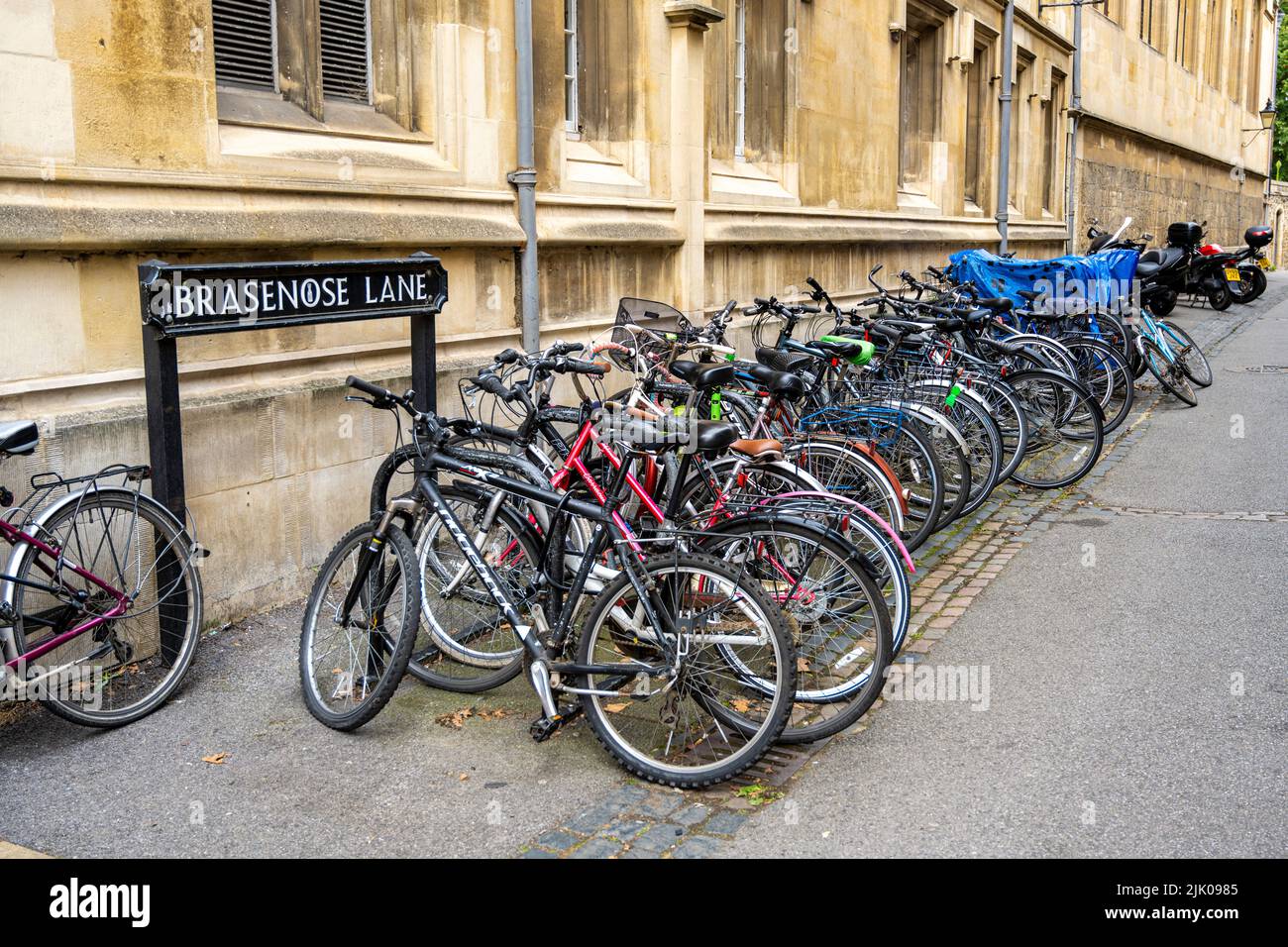 Reihe von Fahrrädern Fahrräder Fahrräder Fahrräder in der Nähe brasenose Lane Straße Straßenschild Oxford England Großbritannien Stockfoto