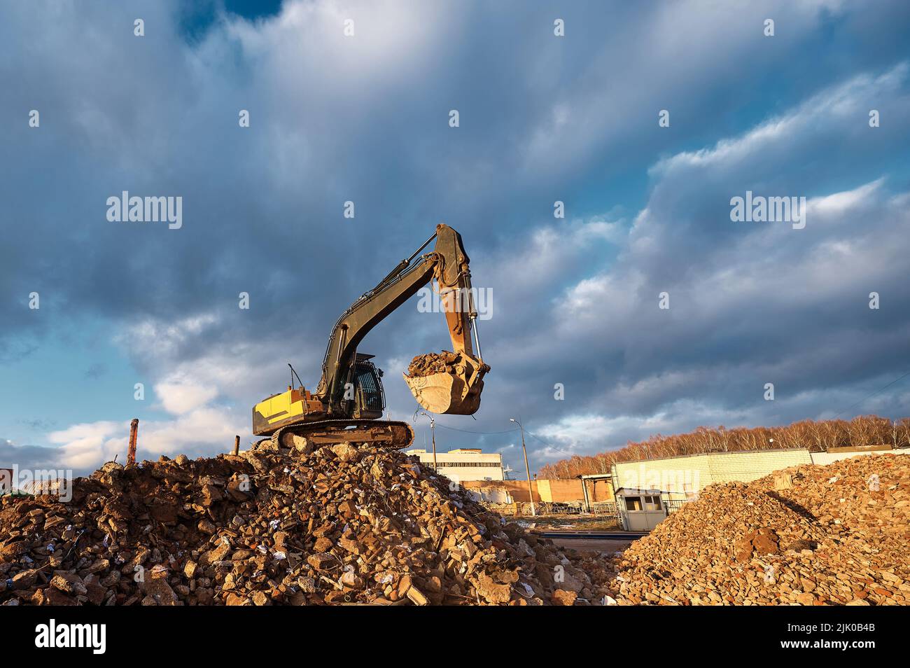 Der Bagger mit Eimer steht auf Betonabfällen Stockfotografie - Alamy