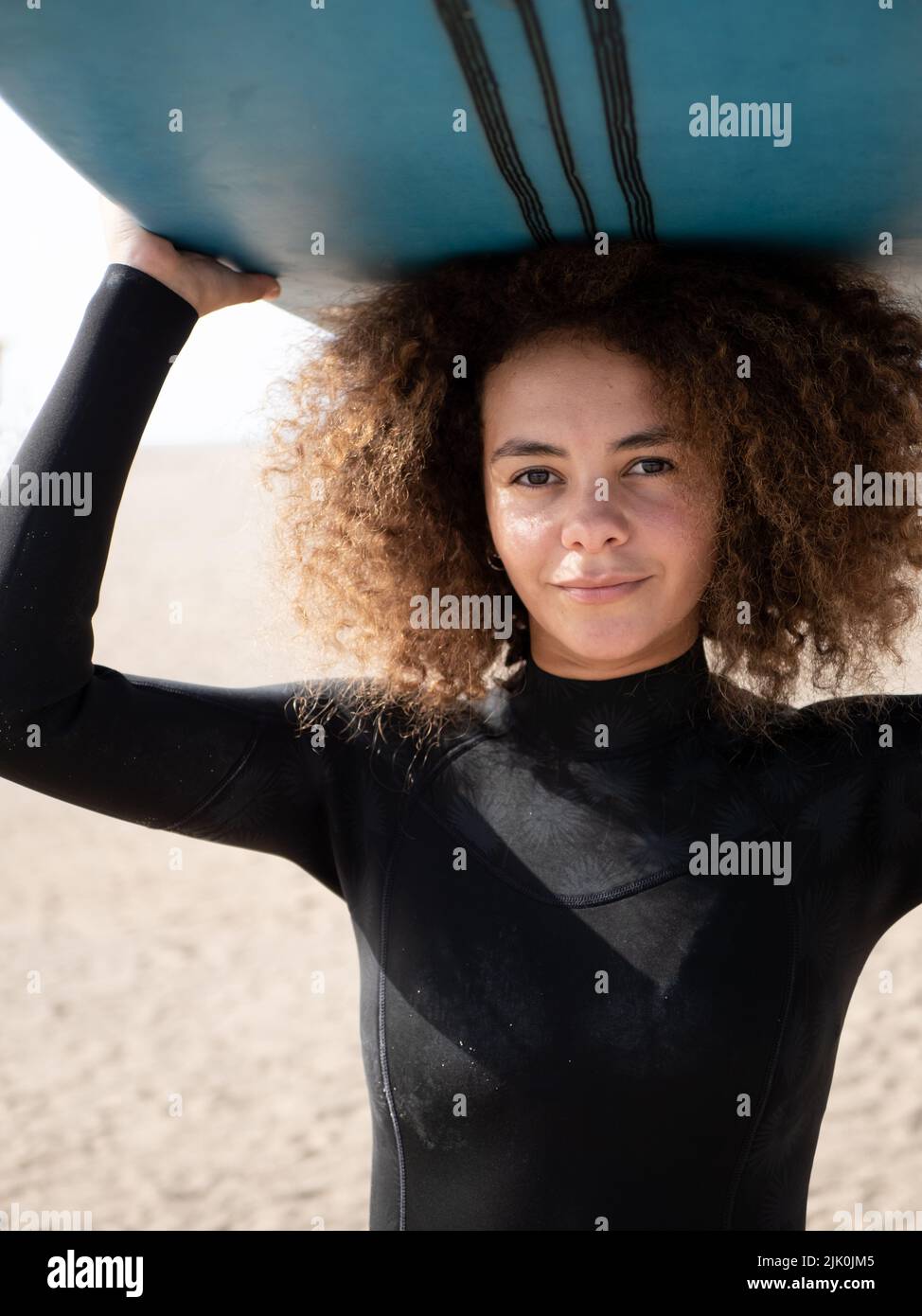 Multirassische Surferin junge Frau mit Afro-Haarportrait Stockfoto