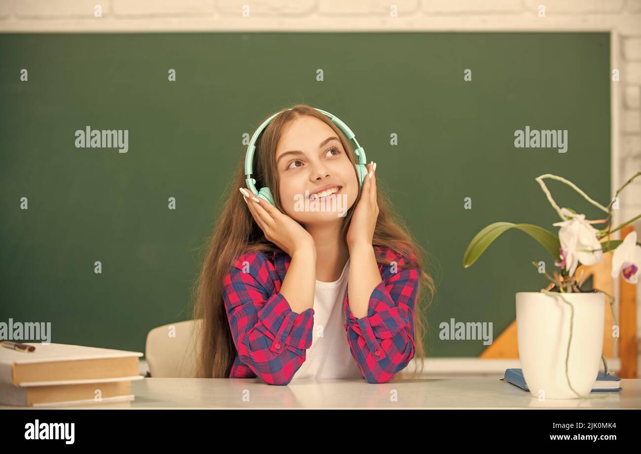 Lächelndes Kind in modernen Kopfhörern. Online-Bildung. Zurück zur Schule. Jugendliches Mädchen in Kopfhörern. Stockfoto