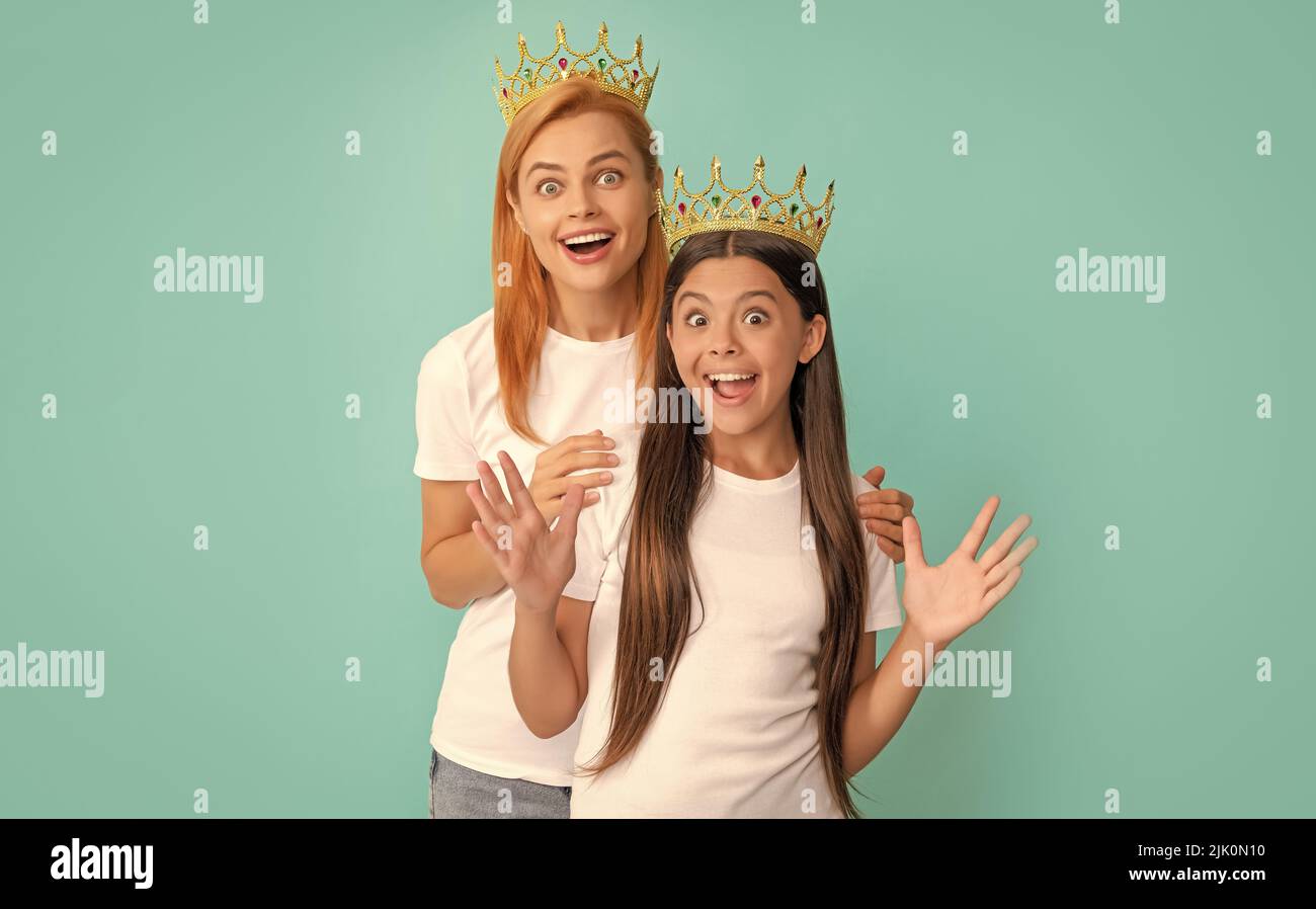 Überrascht Weitäugige egoistische Frau Mutter und Tochter Kind tragen Kronen blauen Hintergrund, Überraschung Stockfoto
