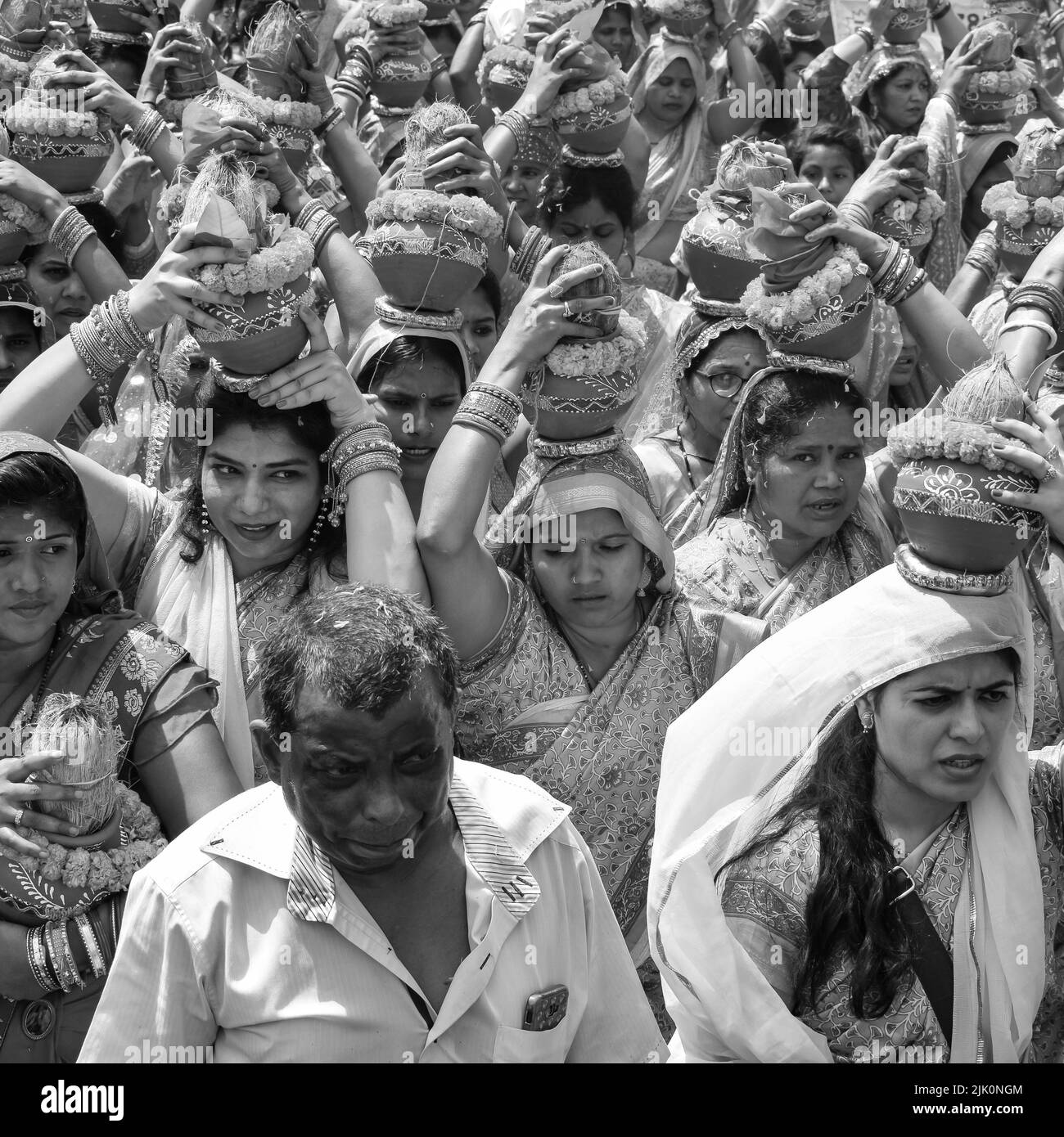 Delhi, Indien April 03 2022 - Frauen mit Kalash am Kopf während des Jagannath-Tempels Mangal Kalash Yatra tragen indische Hindu-Anhänger irdische Töpfe im Container Stockfoto