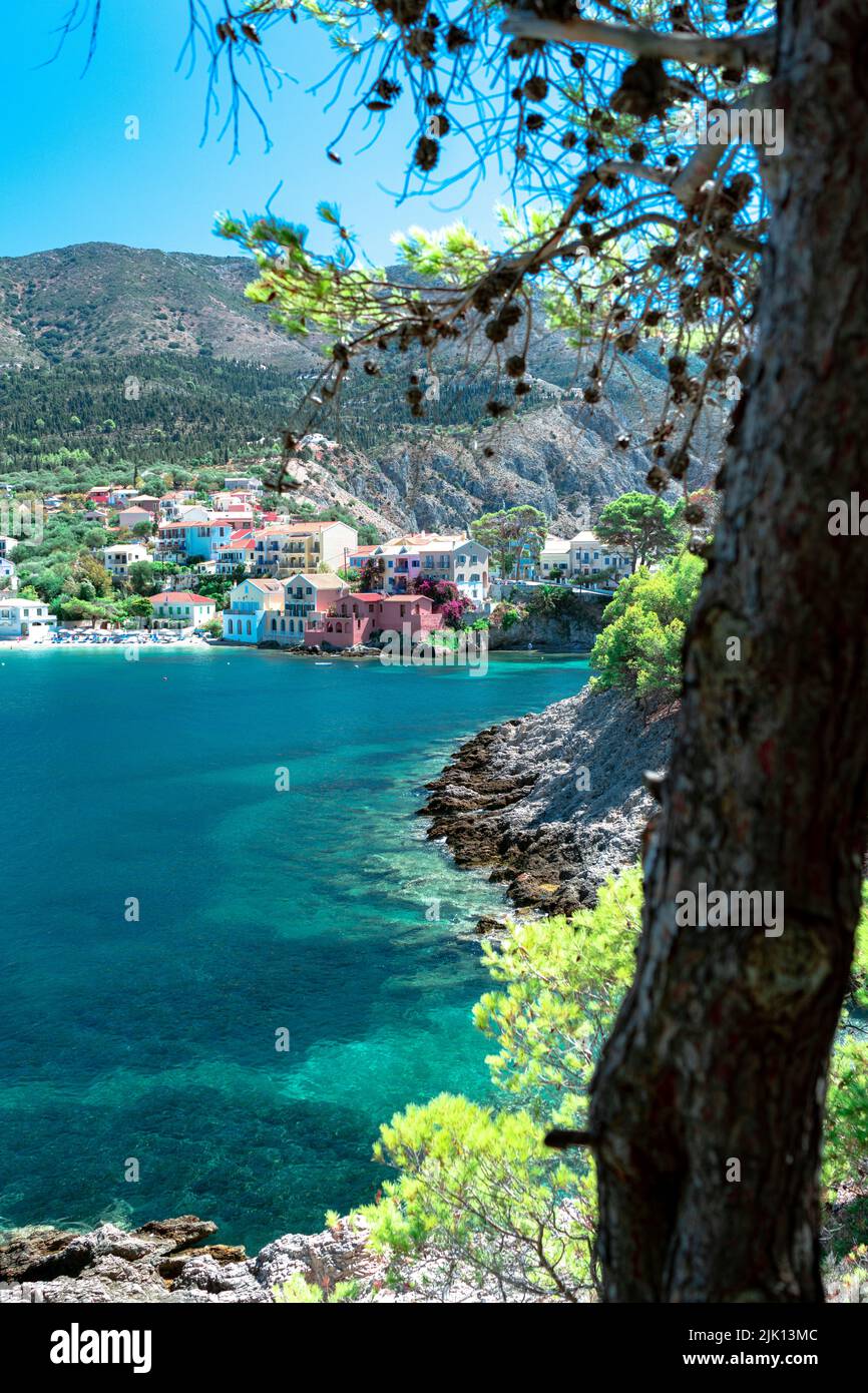 Bunte Gebäude der kleinen Stadt Assos mit Blick auf das türkisfarbene Meer, Assos, Kefalonia, Ionische Inseln, griechische Inseln, Griechenland, Europa Stockfoto