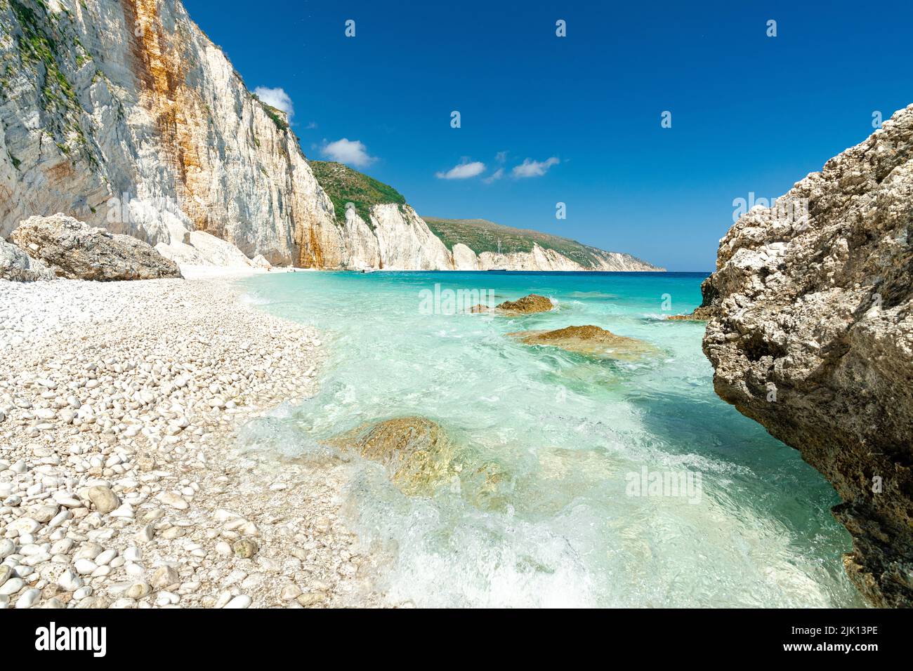 Die Wellen des türkisfarbenen, klaren Meeres waschen die weißen Steine des Fteri-Strandes, Kefalonia, der Ionischen Inseln, der griechischen Inseln, Griechenlands, Europa Stockfoto