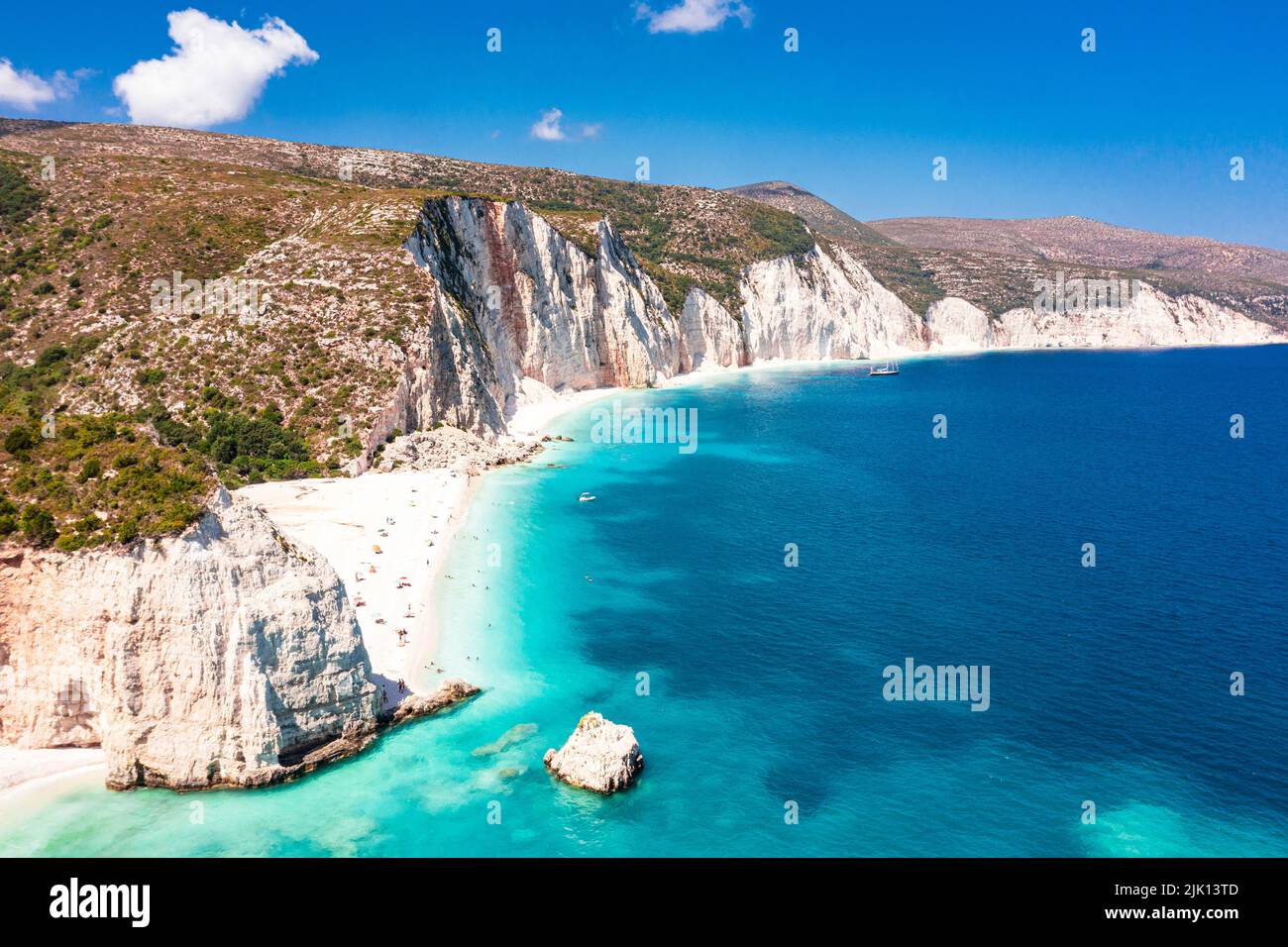 Touristen sonnen sich am idyllischen Fteri Strand, der zwischen Klippen und blauer Lagune liegt, Blick von oben, Kefalonia, Ionische Inseln, griechische Inseln, Griechenland, Europa Stockfoto