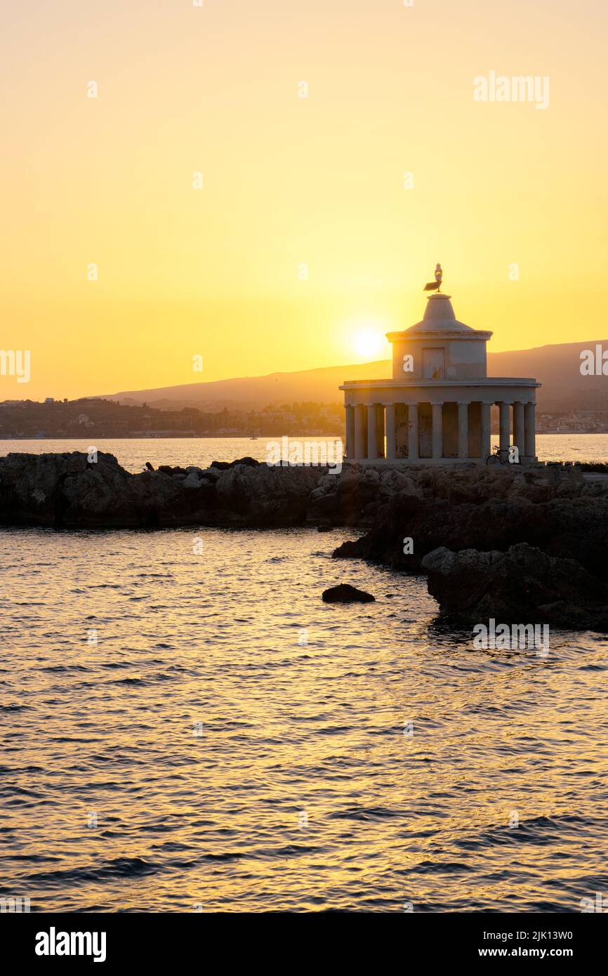 Romantischer Sonnenuntergang über dem Leuchtturm von Saint Theodore, der sich im Meer widerspiegelt, Argostoli, Kefalonia, Ionische Inseln, griechische Inseln, Griechenland, Europa Stockfoto